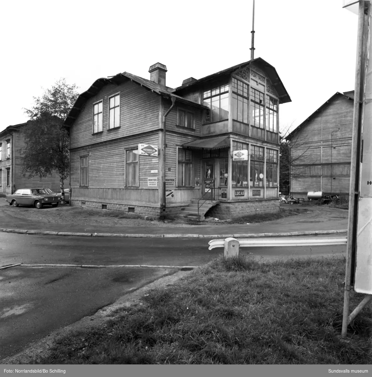 Motordelar B Jansson är en välbekant inrättning för mekande Sundsvallsbor. Firman som startades 1960 på Södra Järnvägsgatan, huserade mellan 1964-1968 i det här trähuset som då fanns på Östra Långgatan 2 med den vackra glasverandan vänd ut mot Parkgatan. Bilden är från hösten 1968, strax innan flytten till mer ändamålsenliga lokaler vid Nybrogatan. Senare bar det av västerut mot det så kallade ”Långholmen”, huset vid Bergsgatan bortom S:t Olofsskolan, och numera (2015) bedrivs verksamheten i egen fastighet i Nacksta industriområde. Exteriör och interiörbilder.