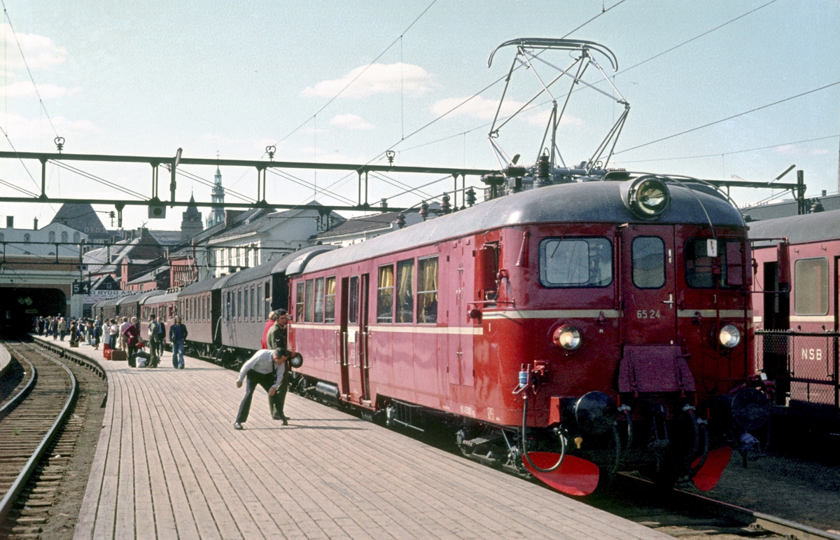 Persontog til Årnes og Eidsvoll med motorvognsett type 65 står klar på Oslo Ø. Toget ble delt i Lillestrøm. Lokomotivfører kontrollerer slaglengden.