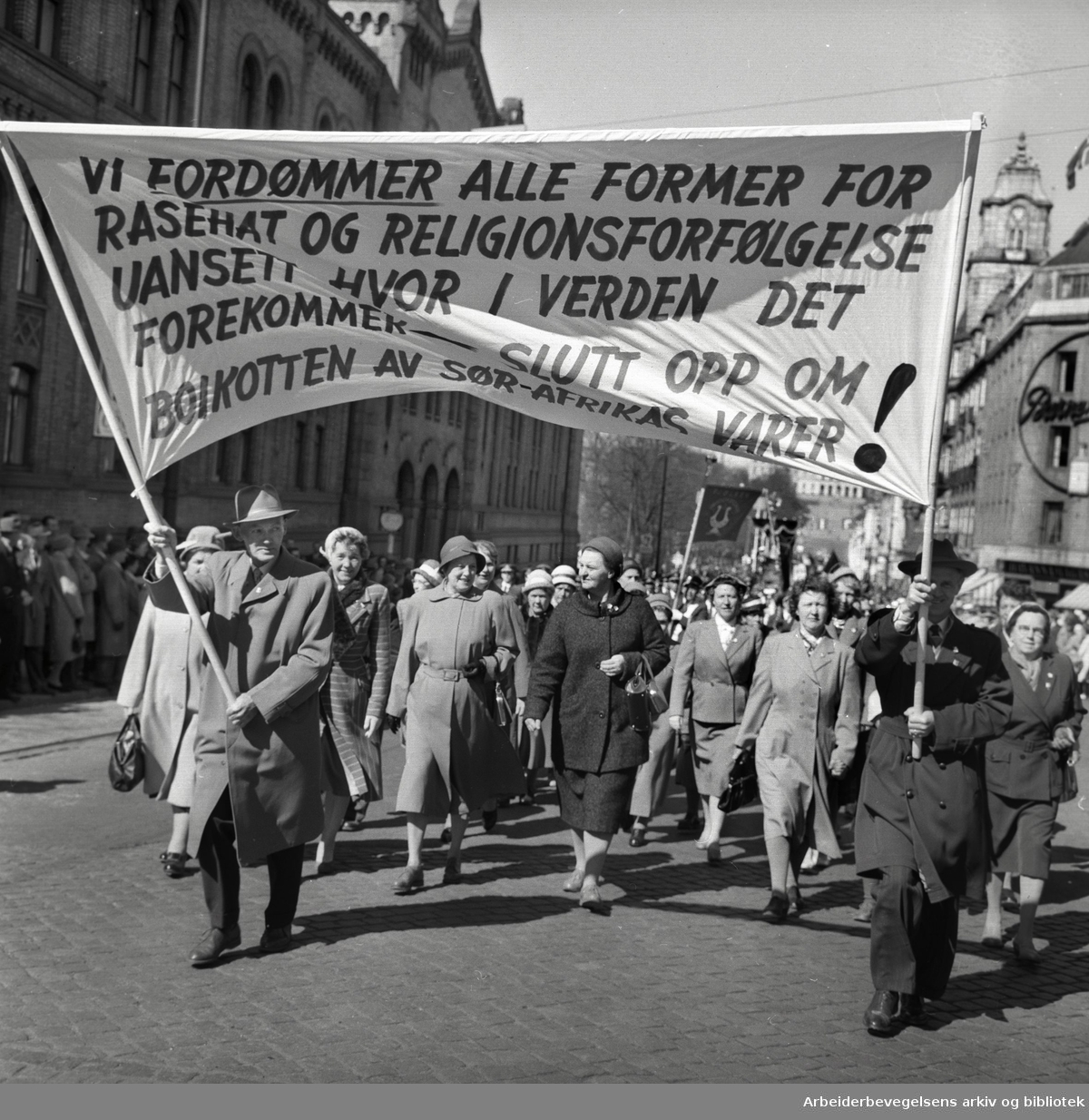 1. mai 1960 i Oslo.Karl Johans gate..Demonstrasjonstoget..Parole: Vi fordømmer alle former for rasehat og religionsforfølgelse uansett hvor i verden det forekommer - Slutt opp om boikotten av Sør-Afrikas varer!.