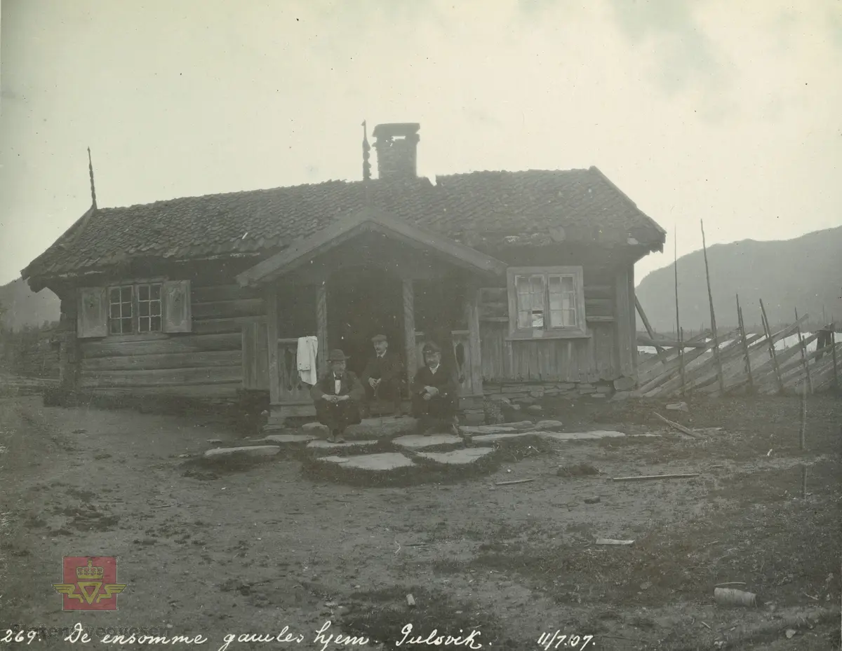 Album fra 1903-1908. Gammel stue i Gulsvik, 11-07 1907.  Tre menn sitter på trappa.