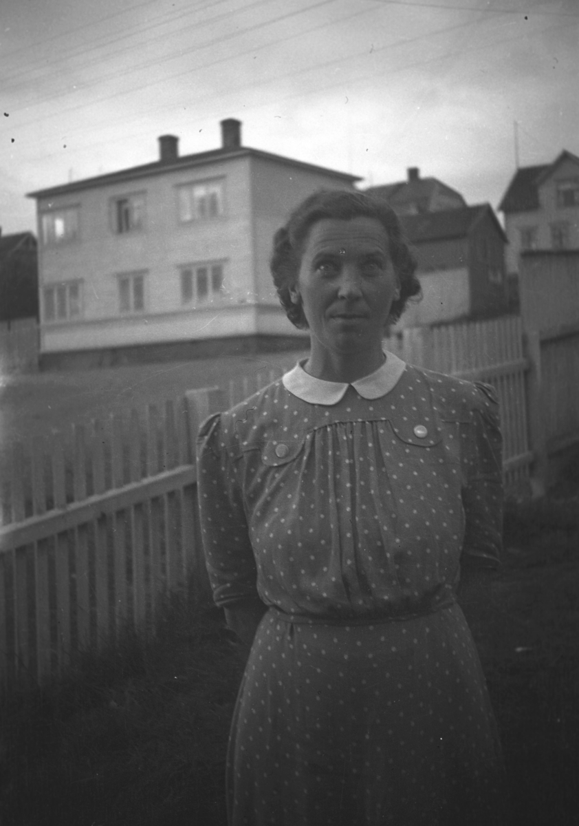 Alfrida Amundsen, datter av Alfred Amundsen, iført en kjole og fotografert i en hage i Vadsø.