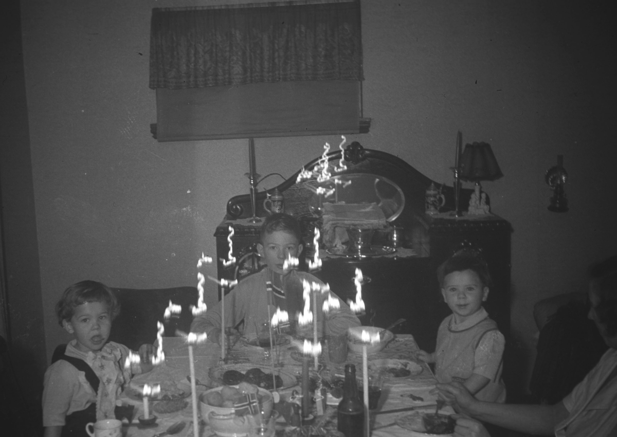 Julefeiring hos familien Hauge under krigen. Barna på bildet er fra venstre: Øystein Hauge, Tor Hauge og Rolf Hauge. Helt til høyre på bildet ses såvidt en dame. Dette kan være Frida Hauge.