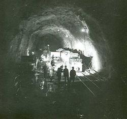 Vannkraftutbygging, lokomotiv med vogner inne i tunnelen.