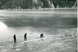 Vannkraftutbygging, tre arbeiderar ute på isen.
