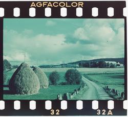 Høystakk, høystakker ved en vei med stabbestein. Bildet tatt