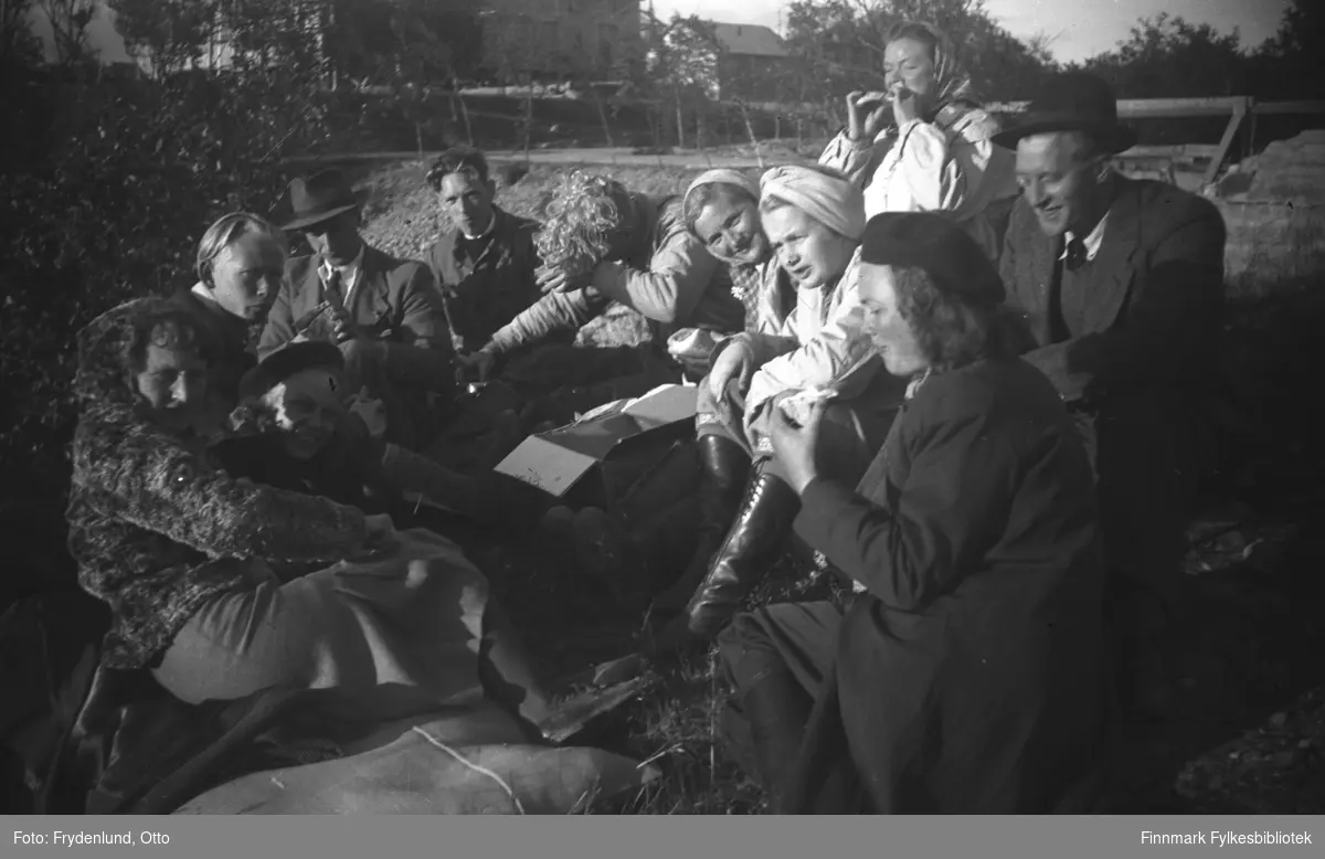 Folk fra Vadsø har tatt turen til Skipagurra i anledning Kong Haakon VIIs besøk 12. juli 1946. De fleste på bildet var ansatt ved Brente steders regulering. Her tar de en matpause