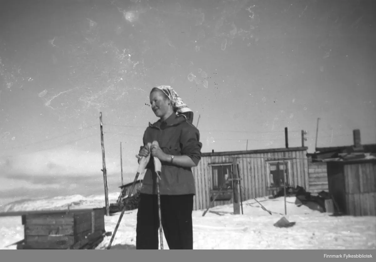 Herlaug Mikkola på ski på Haganes i Kirkenes. I bakgrunnen gjenreisningsbrakker