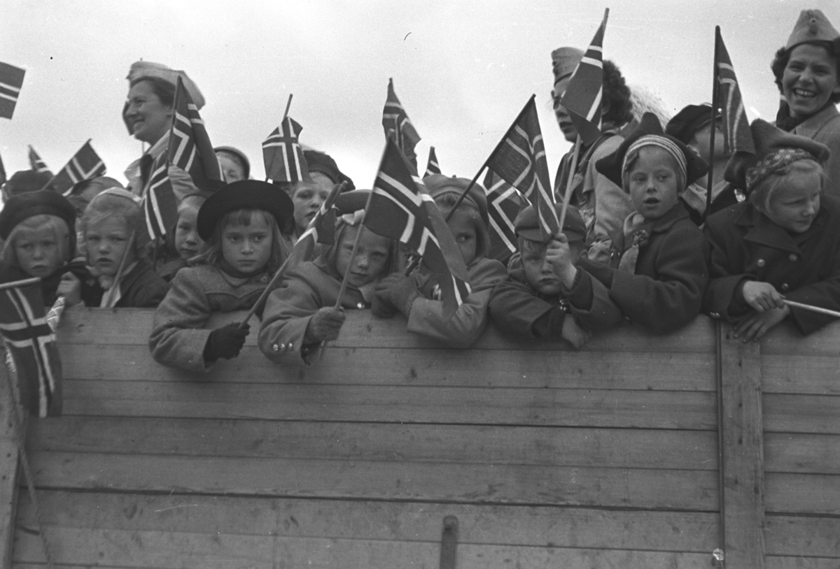 17. mai-feiring i Vadsø. Lotter er satt til å passe barna som er stuet sammen på et lasteplan. Øverst til høyre i bildet ses Hulda Wara. De andre er ukjent.