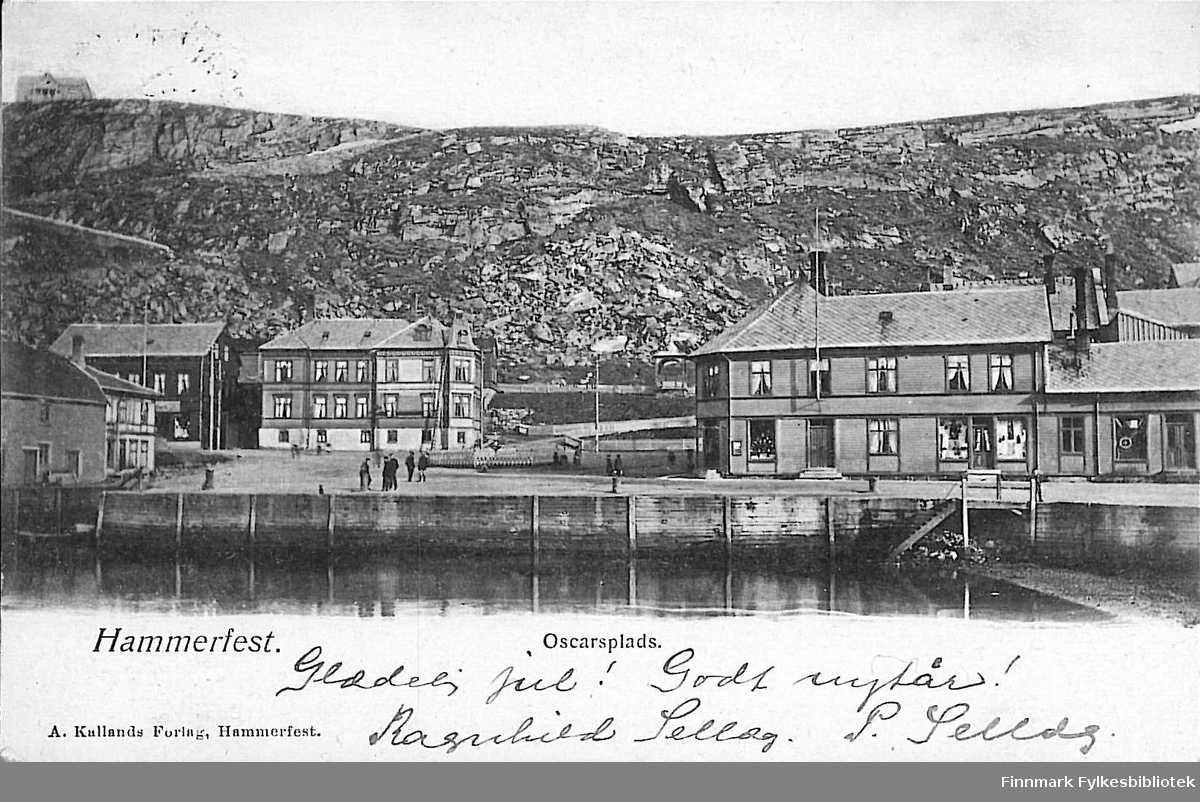 Postkort med motiv fra Hammerfest sentrum. Kortet er en jule- og nyttårshilsen til Arthur og Kirsten Buck på Hasvik. Kortet er sansynligvis sendt mellom 1900-1910.