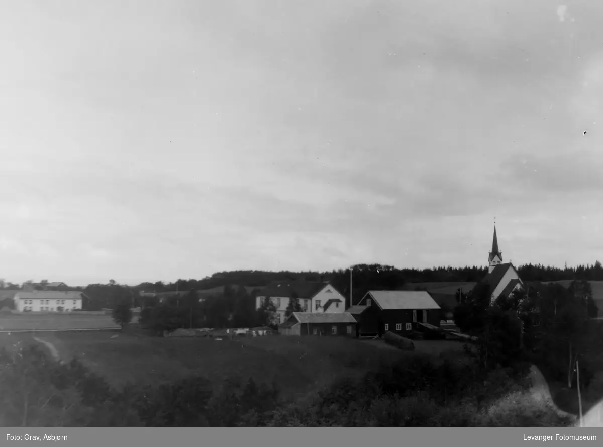 Landskap med stiklestad kirke til høyre, og stiklestad skole til venstre i forgrunn
