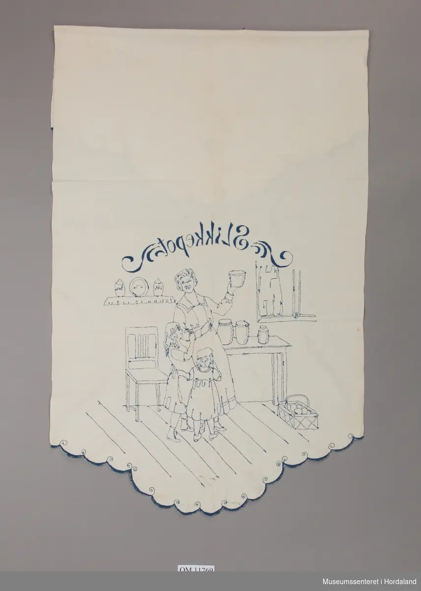 Form: brei, lang, med tungekant i begge ende med motiv av mor på kjøkenet med to jenter, stol, bord, korg, hyller, kar