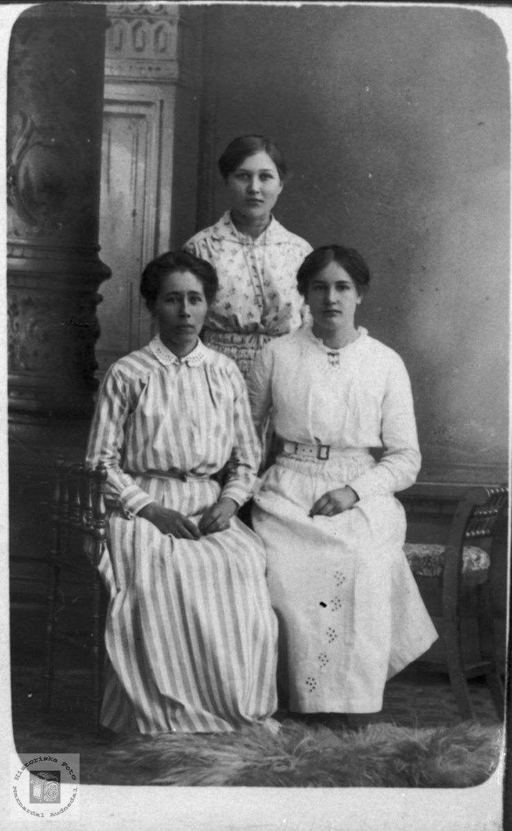 3 unge damer i lyse klær.