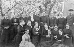 Skoleklasse på atten personer hvorav sytten unge kvinner, op