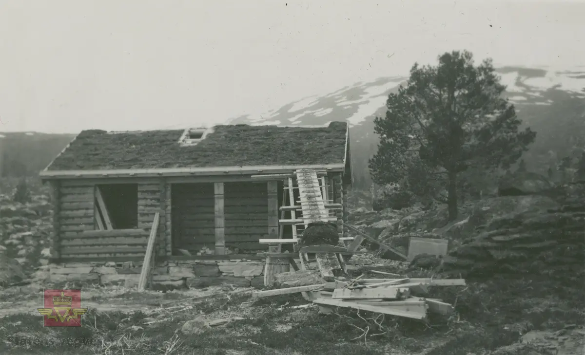 Album fra 1929-1943. Oppføring av tømmerstue med torvtak. Grunnmur av  gråstein. Ukjent sted, sannsynligvis i norddalen.