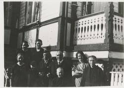 Ti personer foran Berlihuset på Klokkerhaugen.