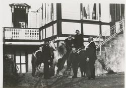 Åtte personer og en ponni foran Berlihuset. Mannen med skjeg