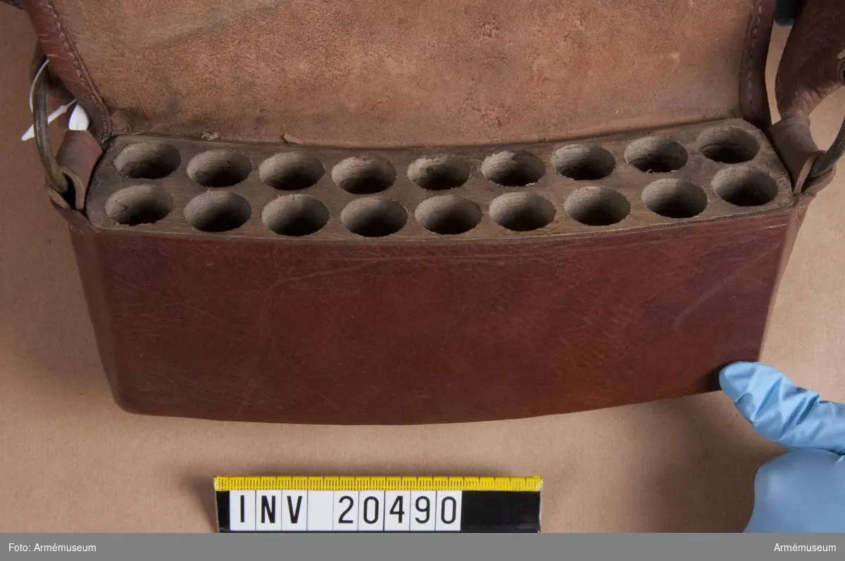 Grupp C II.
Patronkök, menig, husarer, Ryssland, 1802. Består av en träbit i vilken det finns arton fördjupningar för patroner. Den är beklädd med brunt läder. På nedre finns en läderknapp för att stänga väskan.