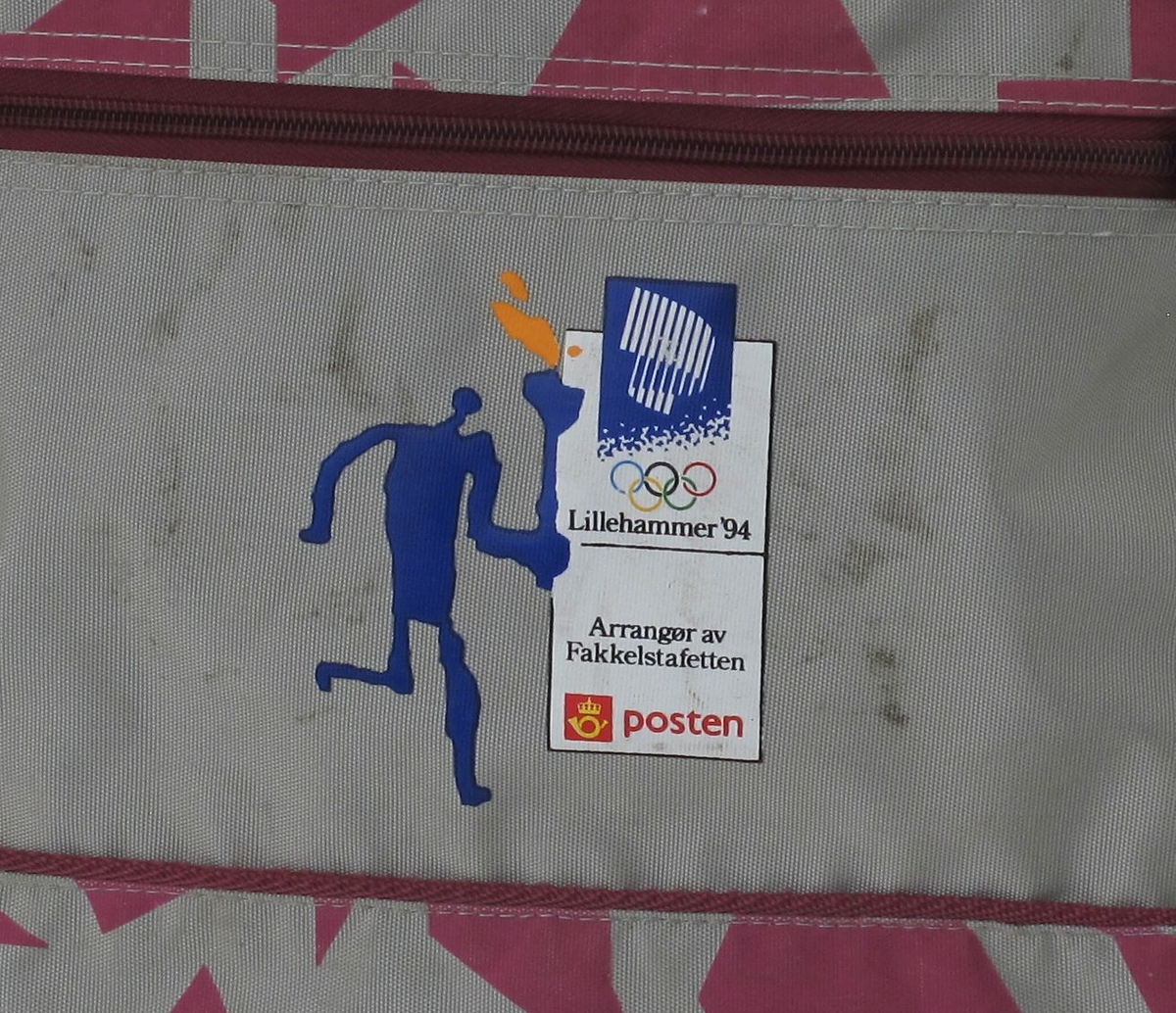 Helleristningsaktig figur som løper med tent fakkel. OL-logo 1994 med nordlys og ringer.