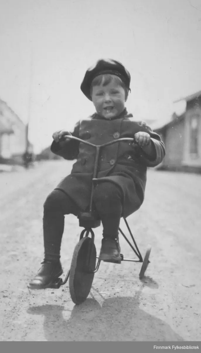 En ukjent gutt på trehjulsykkel. Stedet er også ukjent, men kan være Vadsø.