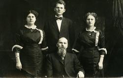 Portrett av to menn og to kvinner. Kvinnene er iført mørke k