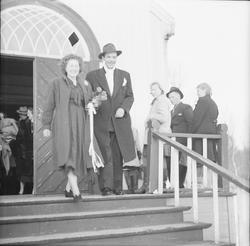 Et nygift par går ned kirketrappen etter vielsen.