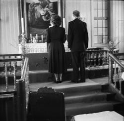 Et brudepar står ved alteret under vielsen.