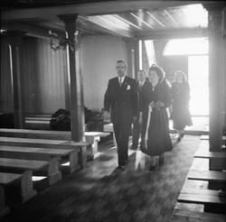 Brud og brudgom går ned kirkegangen mot alteret.