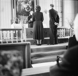 Brud og brudgom står ved alteret. Presten står bak alteret, 