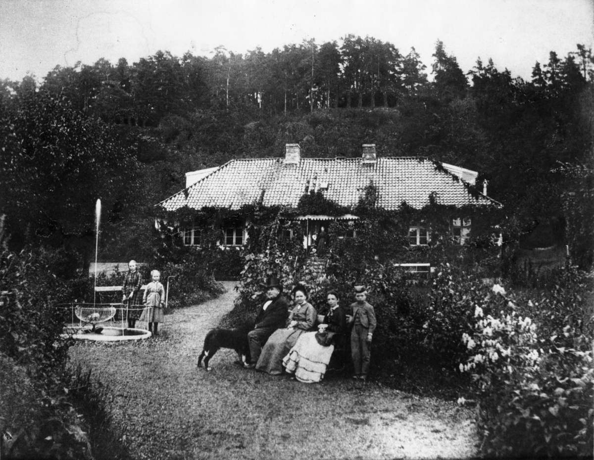 Fotosamling etter Cappelen. Familiebilde tatt i hagen ca. 1875.