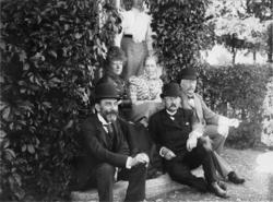 Fotosamling etter Cappelen. Utendørs gruppebilde. Mannen i m