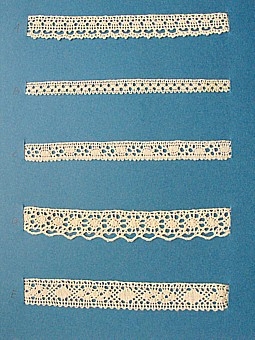 Blått kartongark med fem prover på knypplad skånsk spets från östra Göinge härad. Vid varje prov står en stor bokstav.
A. 13x 1,5 cm
B. 13 x 0,8 cm
C. 13 x 1,2 cm
D. 13 x 1,9 cm
E. 13 x 1,8 cm