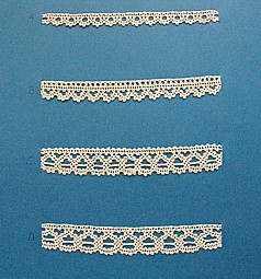 Blått kartongark med fyra prover på skånsk knyppling från Villands härad. Vid varje prov står en stor bokstav.
A. 13 x 1 cm, knypplad med 6 par pinnar
B. 13 x 1,5 cm, knypplad med 8 par pinnar
C. 13 x 2 cm, knypplad med 11 par pinnar
D. 13 x 2 cm, knypplad med 11 par pinnar
