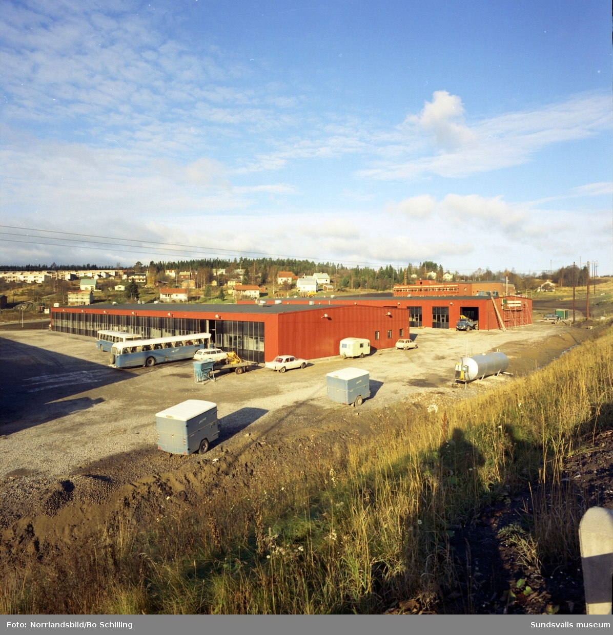 Exteriörbild av Sundfrakts garage och verkstad vid Norra vägen, Råstabacken. Bilden tagen från motorvägen och bakom skymtar Bosvedjan.