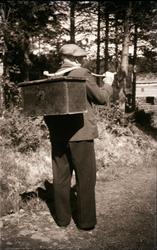 Motiv av en mann som bærer et skrin eller kiste over skulder