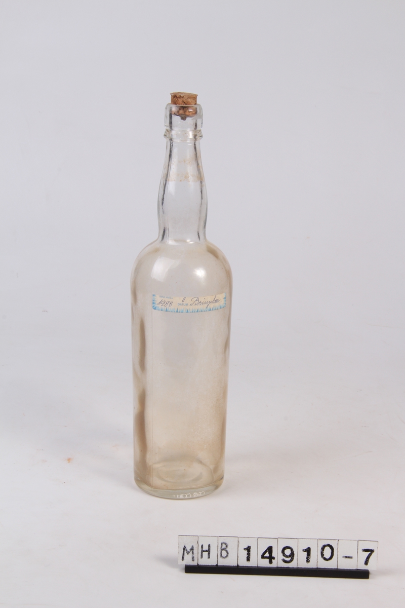 Glassflaske med etikett og trekork. Brukt til oppbevaring av bringerbærsaft.
