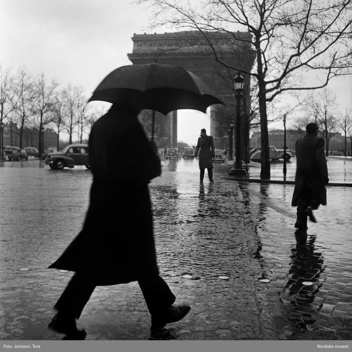 Paris. Man med paraply, Triumfbågen i bakgrunden.