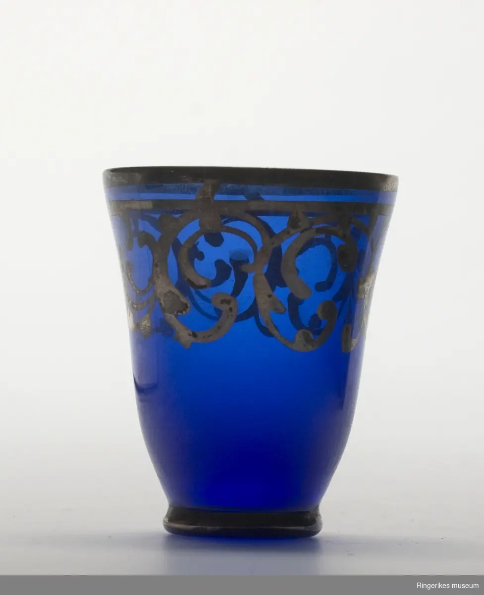 Drammeglass i blått glass med gulldekor.

Et sett som inneholder karaffel og åtte glass.