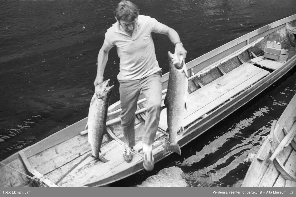 Elvebåt i landskap.

Fotografert mellom 1978 og 1979.

Fotoserie: Laksefiske i Altaelva i perioden 1970-1988 (av Jan Ekman).
