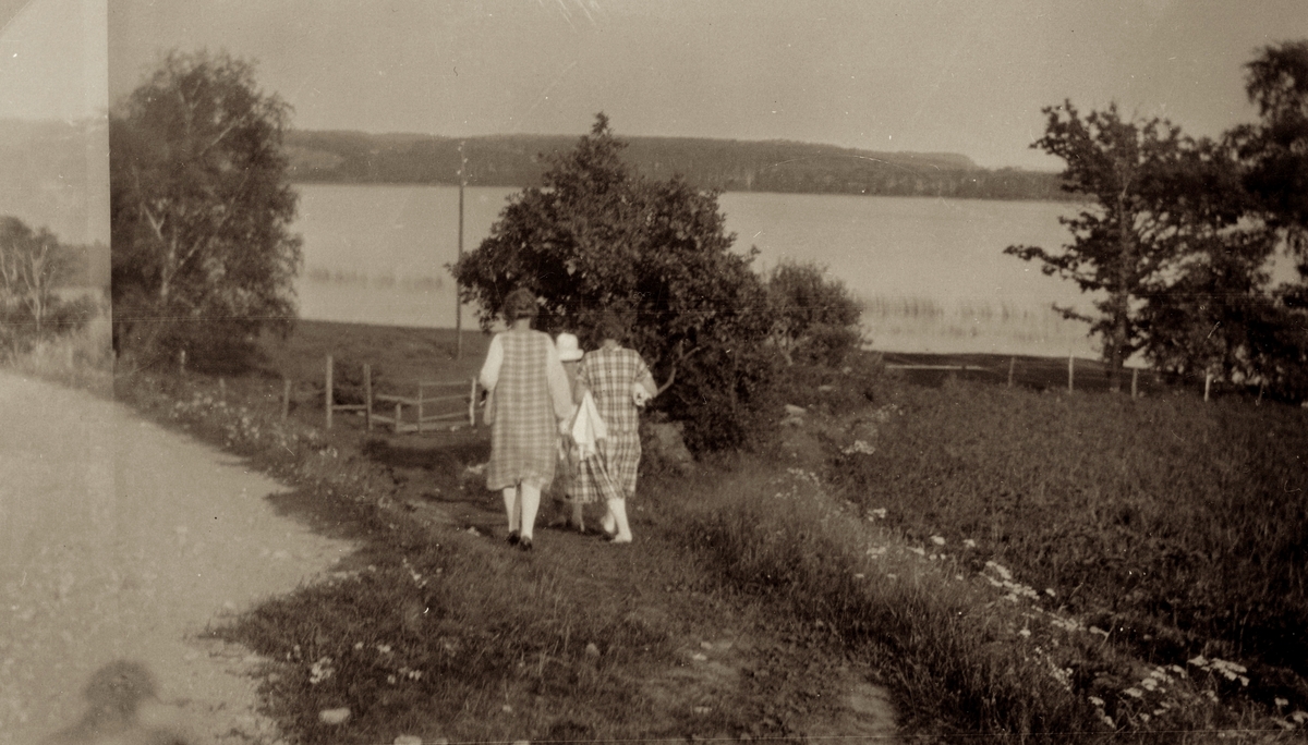 Tre kvinnor med handdukar i händerna promenerar från Stretereds vårdhem till Tulebosjön, cirka 1930.