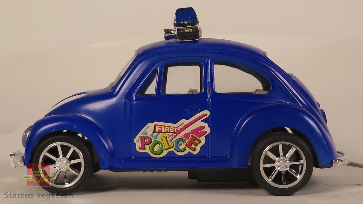 Hovedsakelig blå og sekundært hvit modellbil med sirener, varsellys og en kontroll. Hovedsakelig laget av plast.