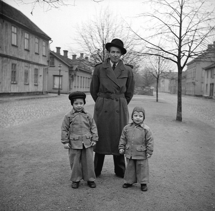 En man och två små pojkar på promenad utmed Kanalgatan i Jönköping.