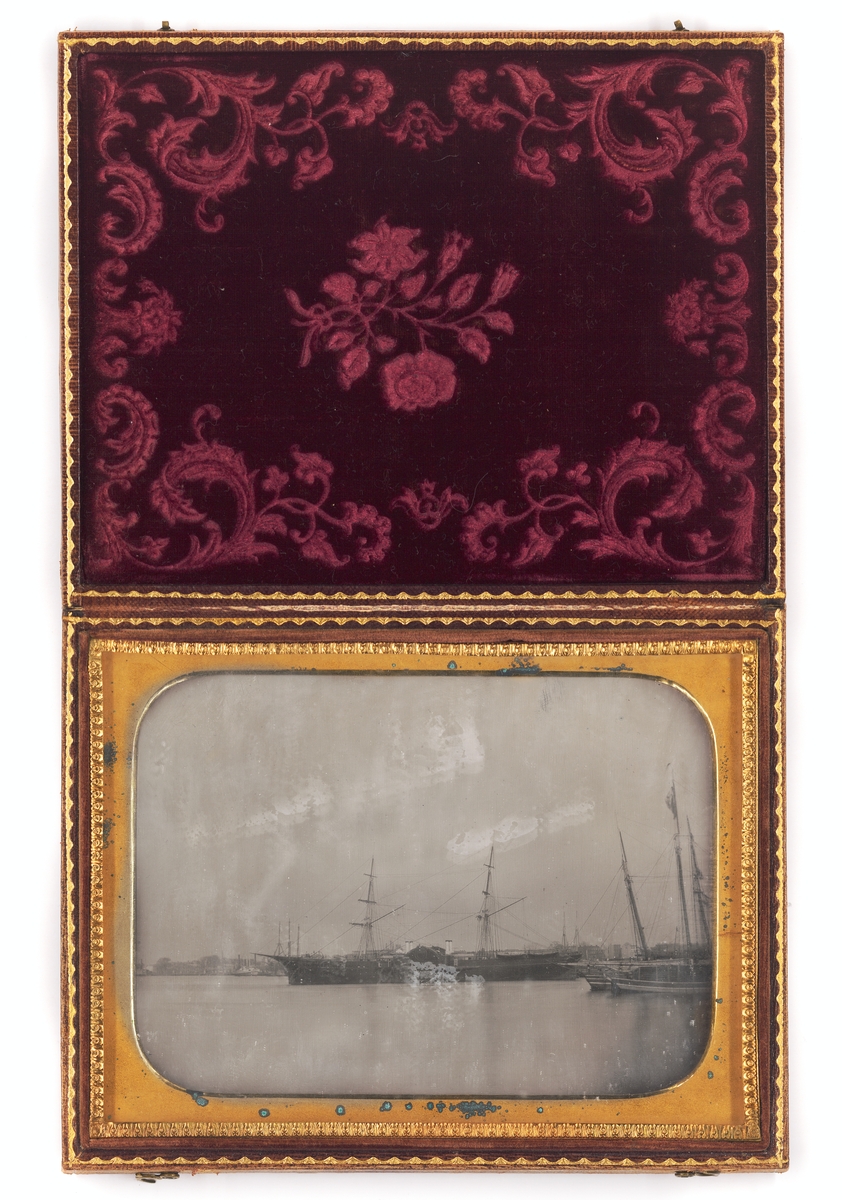 Daguerreotypi, föreställande varmluftsskeppet John Ericsson, infattad i ett läderetui med ornamentering. Locket fodrat med mönstrad röd silkessammet.