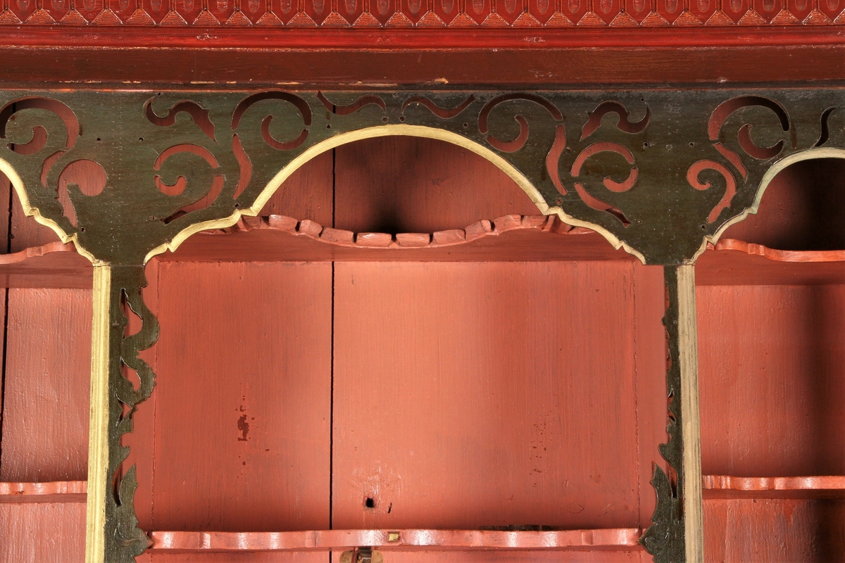 Rødmalt skatoll med figurative malerier i dørspeilene. Den nedre delen har buede skuffefronter. Den røde utvendige malingen er muligens sekundær. 