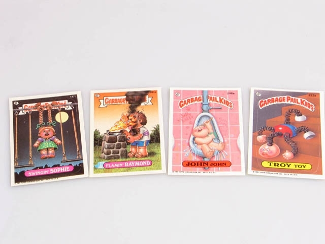 Kort med klistermärken. Korten föreställer "Garbage Pail Kids". Dessa var populära att samla på under 1980-talet. Med korten kom ett rosa tuggummi. Garbage Pail Kids kom först 1985, och var en slags parodi på de på 1980-talet populära kåldockorna (Cabbage Patch Kids). Det har även gjorts en film och en tecknad serie på Garbage Pail Kids-temat.