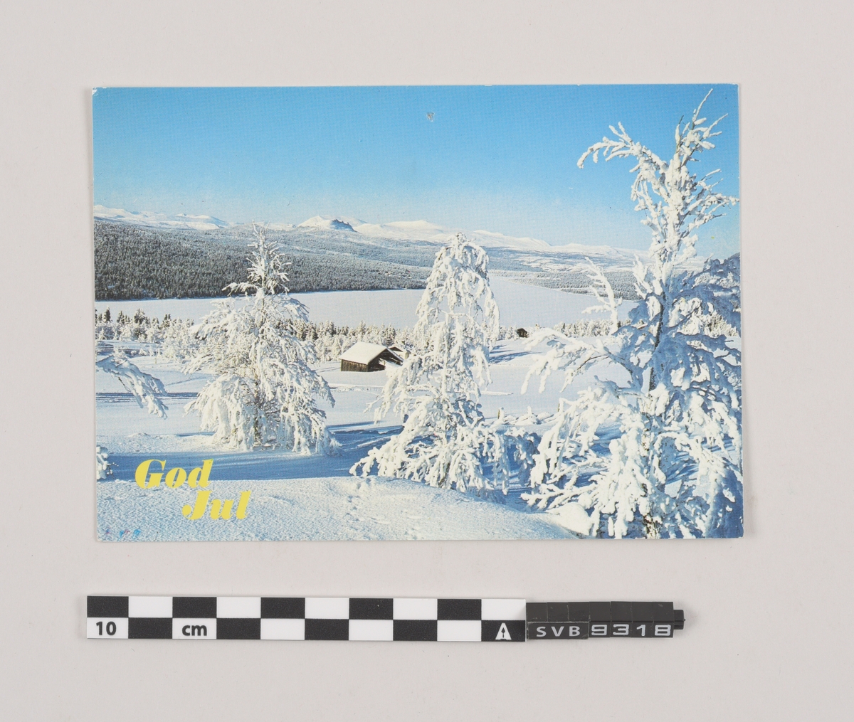 Tosidig kort. Fotografi av vinterlandskap og trykk på forsiden, frimerke, stempel, klistermerke, trykk og håndskrevet hilsen på baksiden.