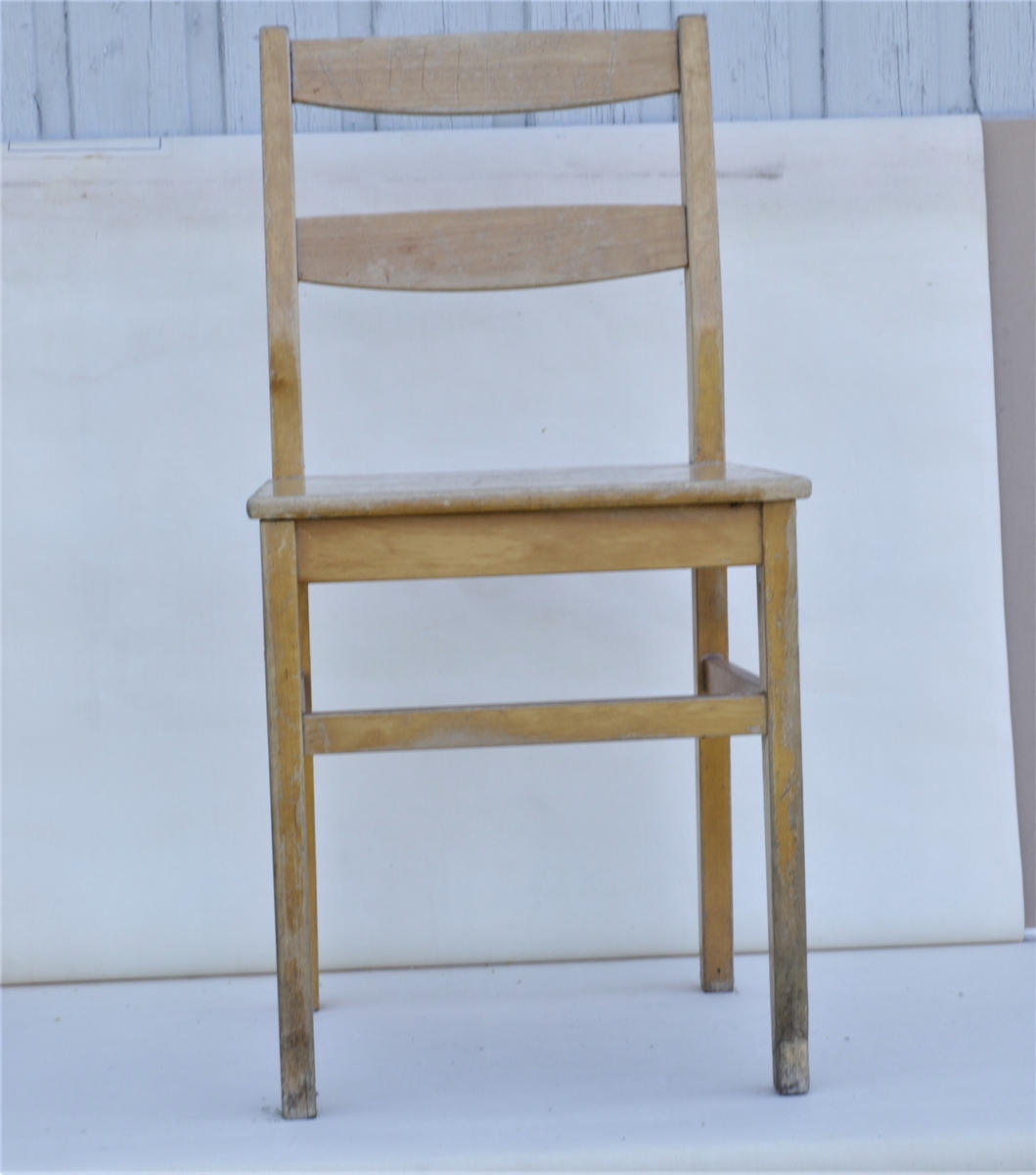 Barnestol av lakkert treverk brukt i klasserommet på skolen.