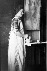 Kvinne skjenker kaffe på et kjøkken.