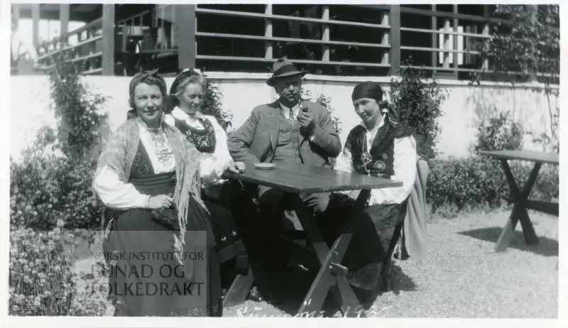 Tre kvinner, med bunad (Klara Semb til v.) og en mann i motedrakt