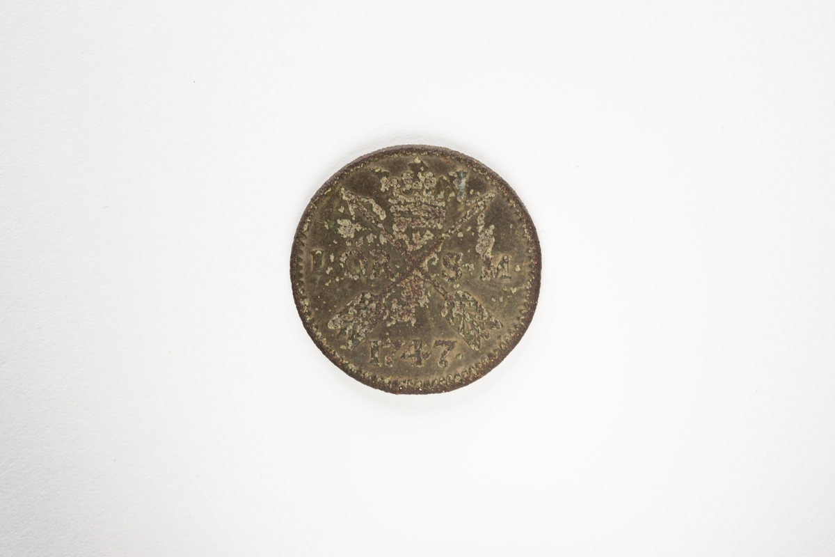 Mynt av koppar, 1 öre, 1747, Fredrik I. Sida 1: krönt spegelmonogram "F". Sida 2: två krönta, korslagda dalpilar, omgivna av texten "1 ÖR SM 1747"