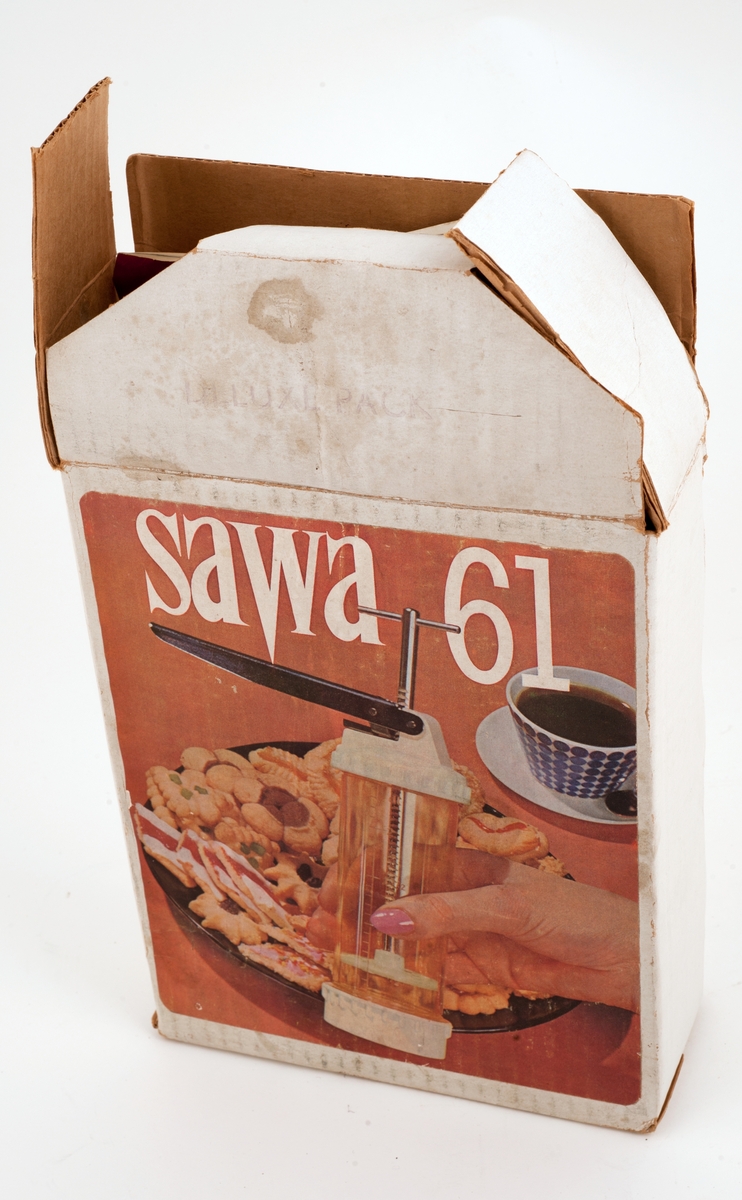 Sawa 61 kjøkkenspryte i tilhørende boks,  med bruksanvisning.
På pakken er det også påklistsret postoppkrav over postgiro til Åsta Vik, moren til Tone Vik,  med adresse, og pris, 54 kroner og 50 øre.